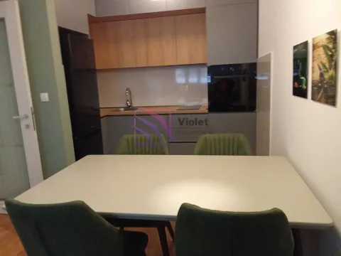Modern kitchen with a dining table and green chairs. - image 4