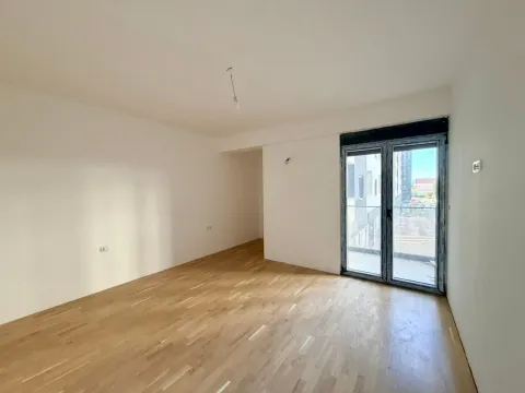 Prazna soba sa parketom i balkonskim vratima. - image 2
