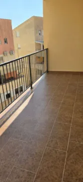 Prostrani popločani balkon sa metalnom ogradom i pogledom na susjedne zgrade. - image 9