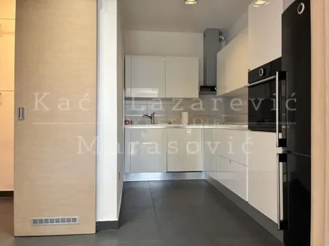 Modern white kitchen with built-in appliances and dark floor tiles. - image 8