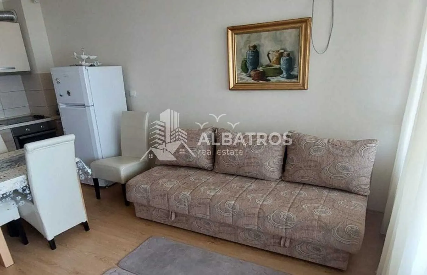 Smaller living room with a sofa and a dining table in the continuation.
