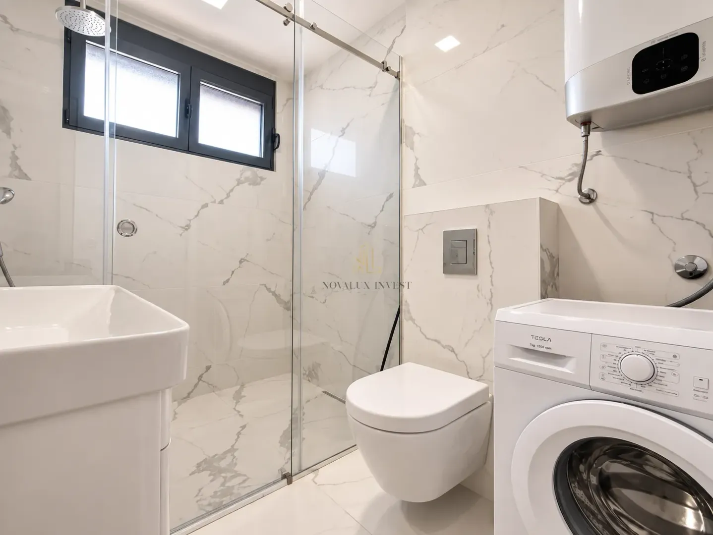 Modern bathroom with a walk-in shower, toilet, washbasin, and washing machine.