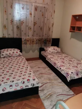Dječija spavaća soba sa dva kreveta i šarenom posteljinom. - image 3