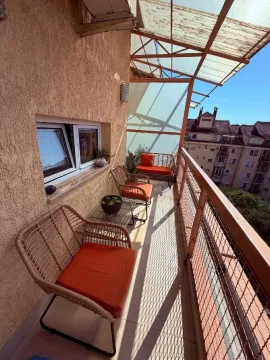Dugačka natkrivena terasa sa garniturom za sedenje i pogledom na grad. - image 5