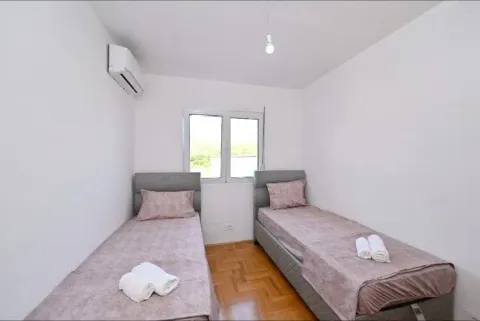 Spavaća soba sa dva odvojena kreveta i klima uređajem. - image 7