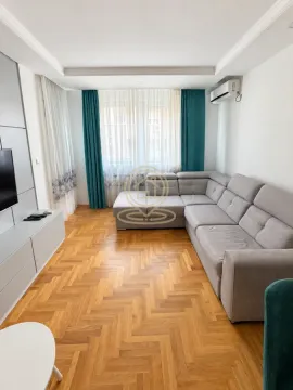 Dnevna soba sa ugaonom garniturom, TV komodom i drvenim parketom. - image 3