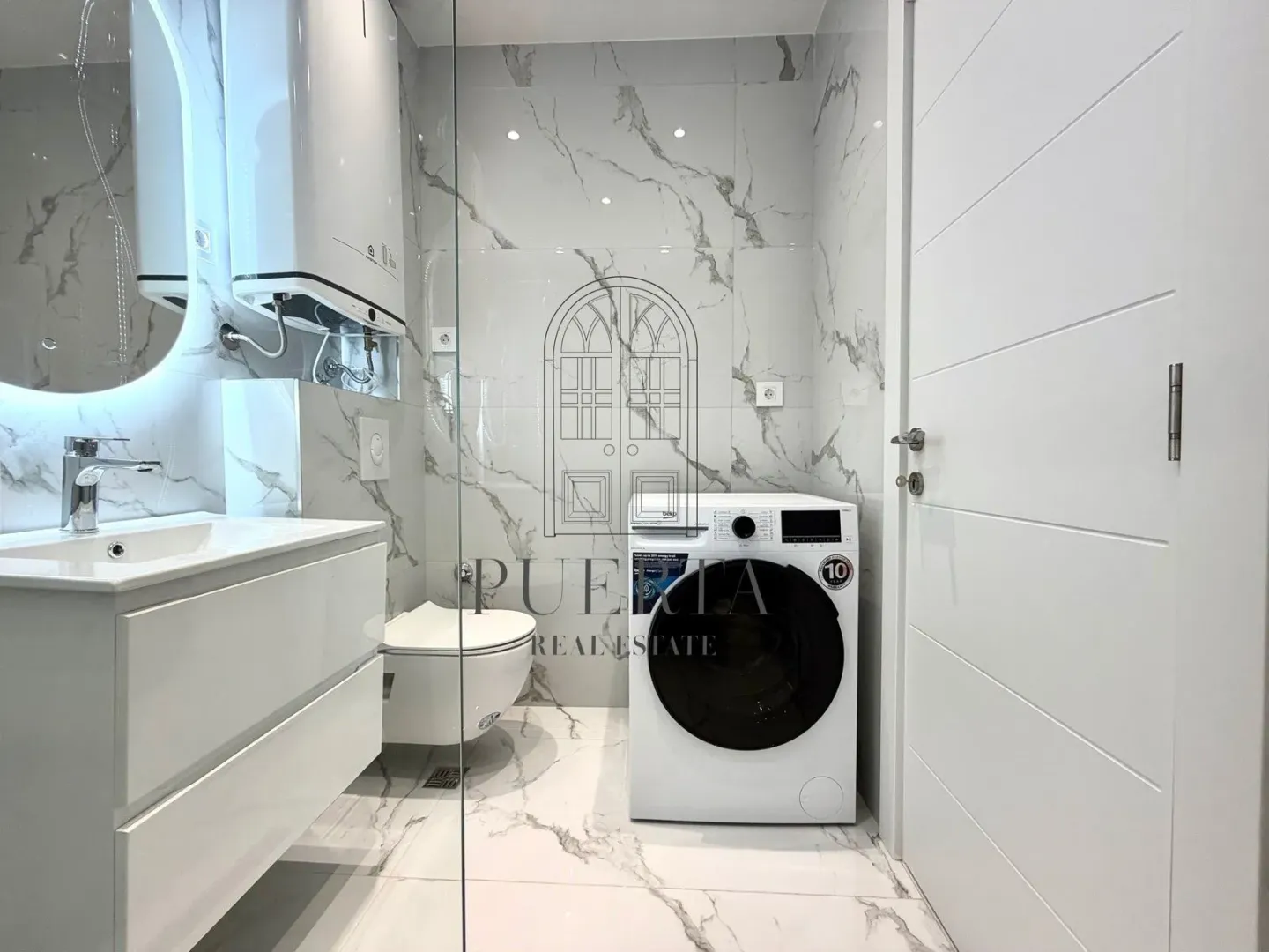Moderne kupatilo sa umivaonikom, wc šoljom i veš mašinom.