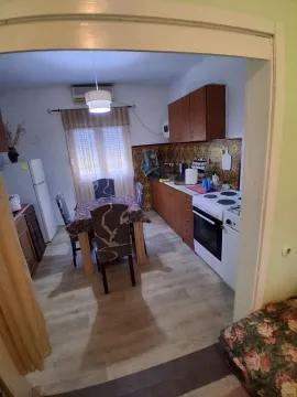 Manja kuhinja sa trpezarijskim stolom i drvenim elementima. - image 3
