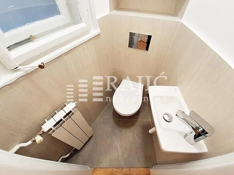 Small bathroom with toilet, washbasin, and radiator.