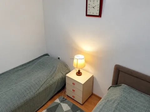 Bedroom with two beds and a nightstand. - image 8
