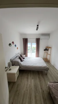 Spavaća soba sa bračnim krevetom, noćnim stočićem i izlazom na terasu. - image 5