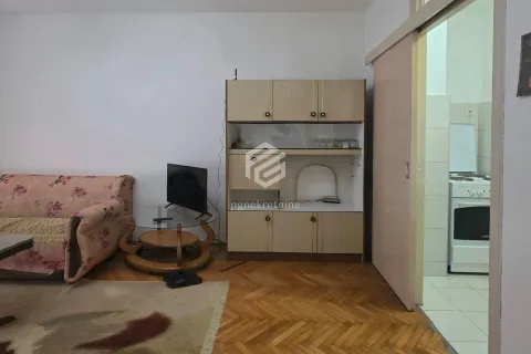 Living room with a sofa, TV, and a view of the kitchen. - image 12