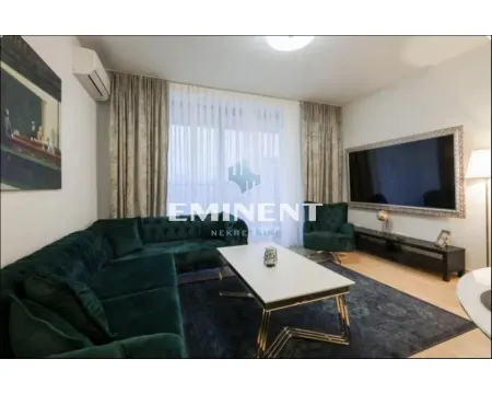 Living room with a green sectional sofa, coffee table, and wall-mounted TV. - image 4