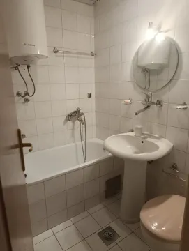 Manje kupatilo sa kadom, umivaonikom i wc šoljom obloženo keramičkim pločicama. - image 8