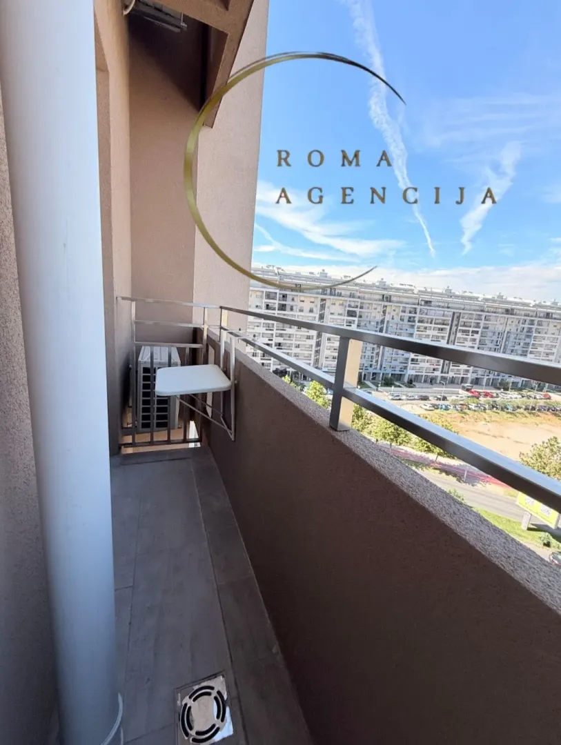 Small balcony with a metal railing and a view of the neighborhood.