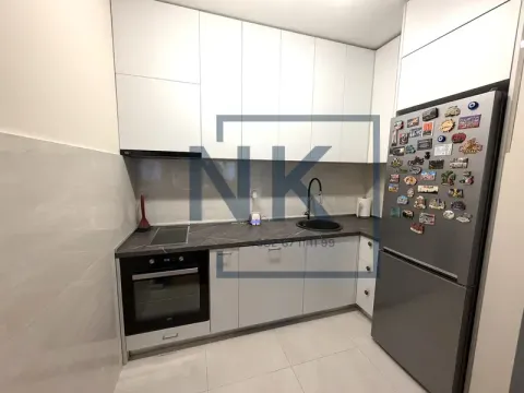 Moderna bijela kuhinja sa tamnom radnom pločom i ugradnim aparatima. - image 4