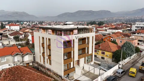 Pogled iz vazduha na novu stambenu zgradu u izgradnji sa okruženjem i planinama u pozadini. - image 2