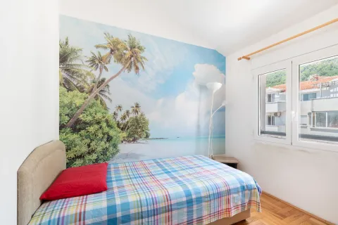 Bedroom with a bed and a beach-themed accent wall. - image 6