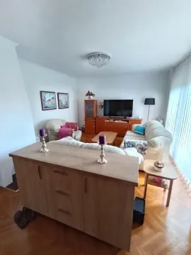 Nameštena dnevna soba sa garniturom, televizorom i drvenim nameštajem. - image 19