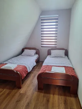 Potkrovlje opremljeno sa dva drvena kreveta i prozorom. - image 7