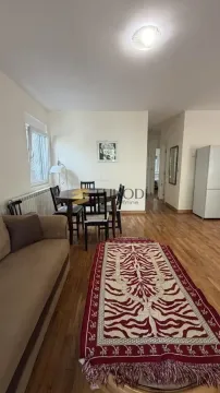 Living room with a dining area and parquet flooring. - image 4