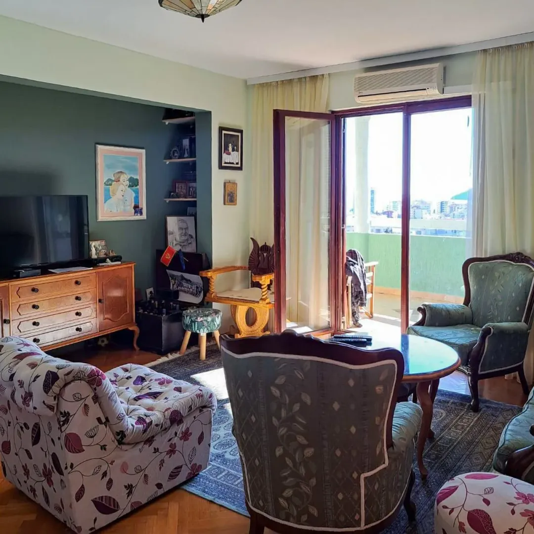 Dnevna soba sa garniturom za sjedenje i izlazom na terasu.