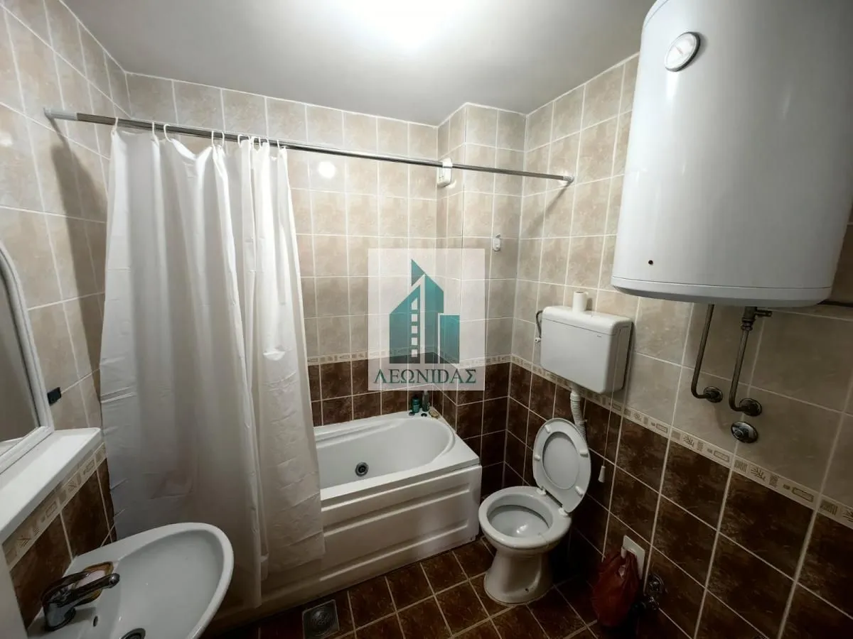 Bathroom equipped with a bathtub, washbasin, toilet, and water heater.