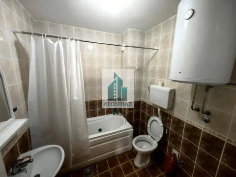 Bathroom equipped with a bathtub, washbasin, toilet, and water heater. - image 13