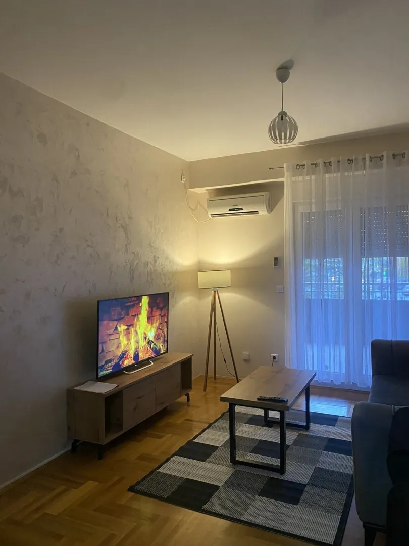 Living room with a television, coffee table, and decorative lighting.