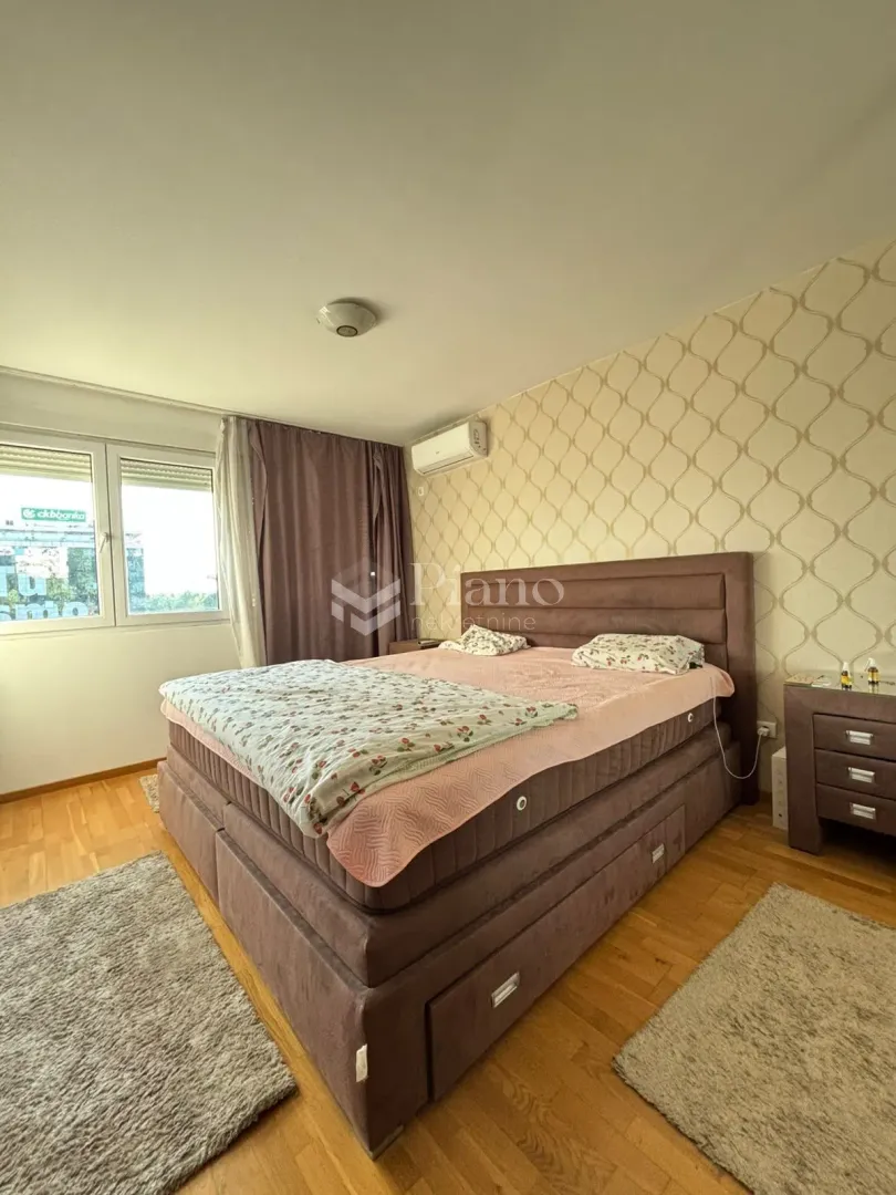 Furnished bedroom with a double bed, bedside tables, and a window.