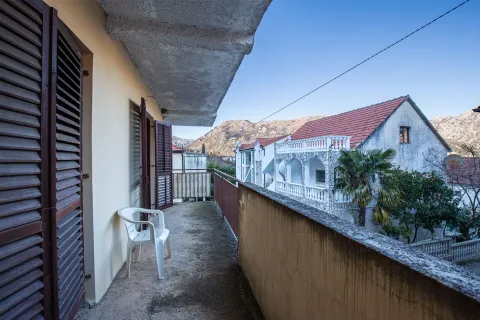 Natkriveni balkon sa pogledom na okolne zgrade i planine. - image 27