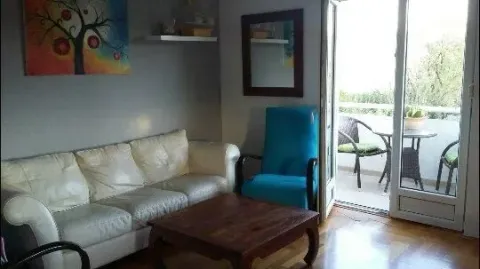 Living room with a leather sofa and access to a furnished balcony. - image 4