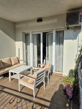 Furnished terrace with seating set and glass balcony doors. - image 8