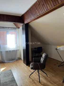 Attic room with wooden ceiling beams, parquet flooring and a desk by the window. - image 3