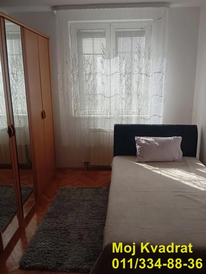 Small bedroom with a bed, wardrobe, and window.