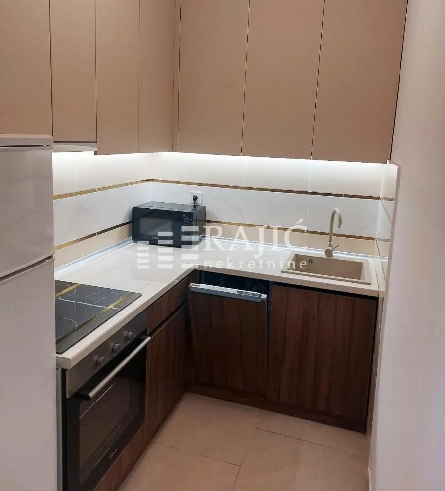 Smaller modern kitchen with built-in units and white countertops.