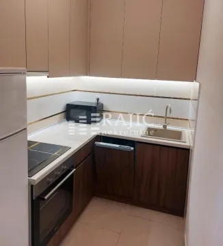 Smaller modern kitchen with built-in units and white countertops. - image 5