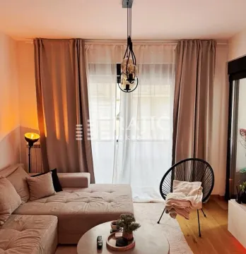 Uređena dnevna soba sa garniturom i prozorom prekrivenim zavesama. - image 4