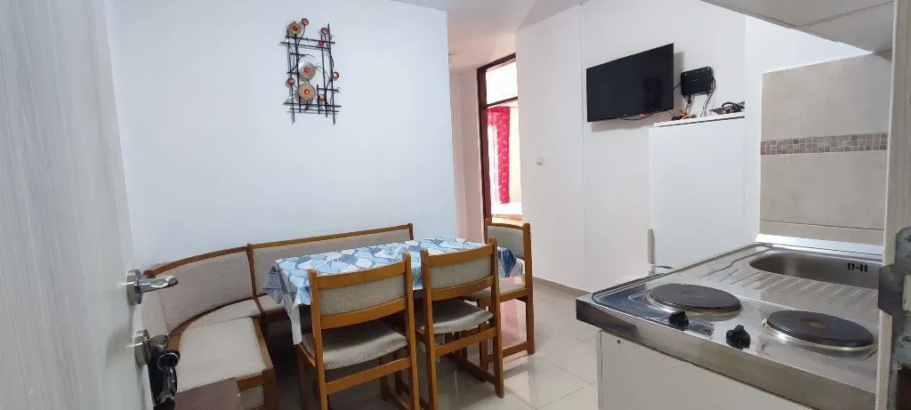 Dining area with a dining table and kitchen units in the background.