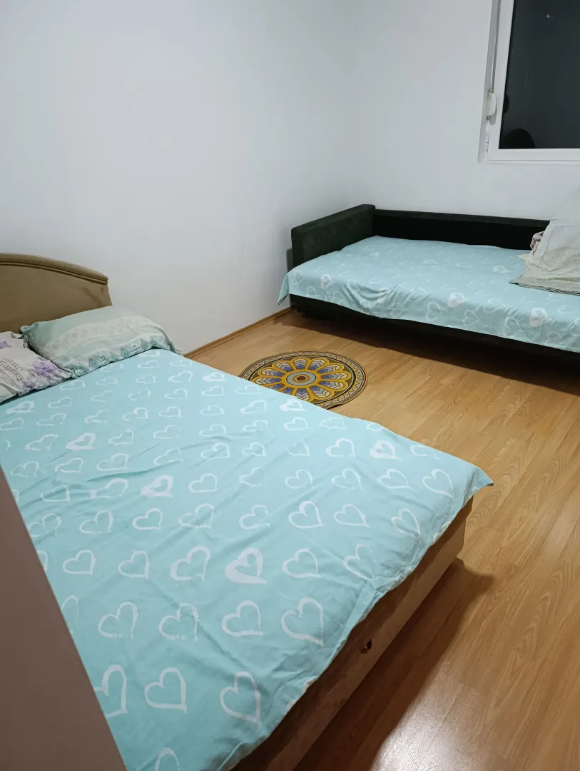 Bedroom with two beds and laminate flooring.