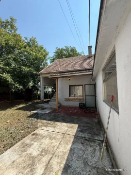 Pogled na dvorište i spoljašnjost kuće sa popločanim delom. - image 2