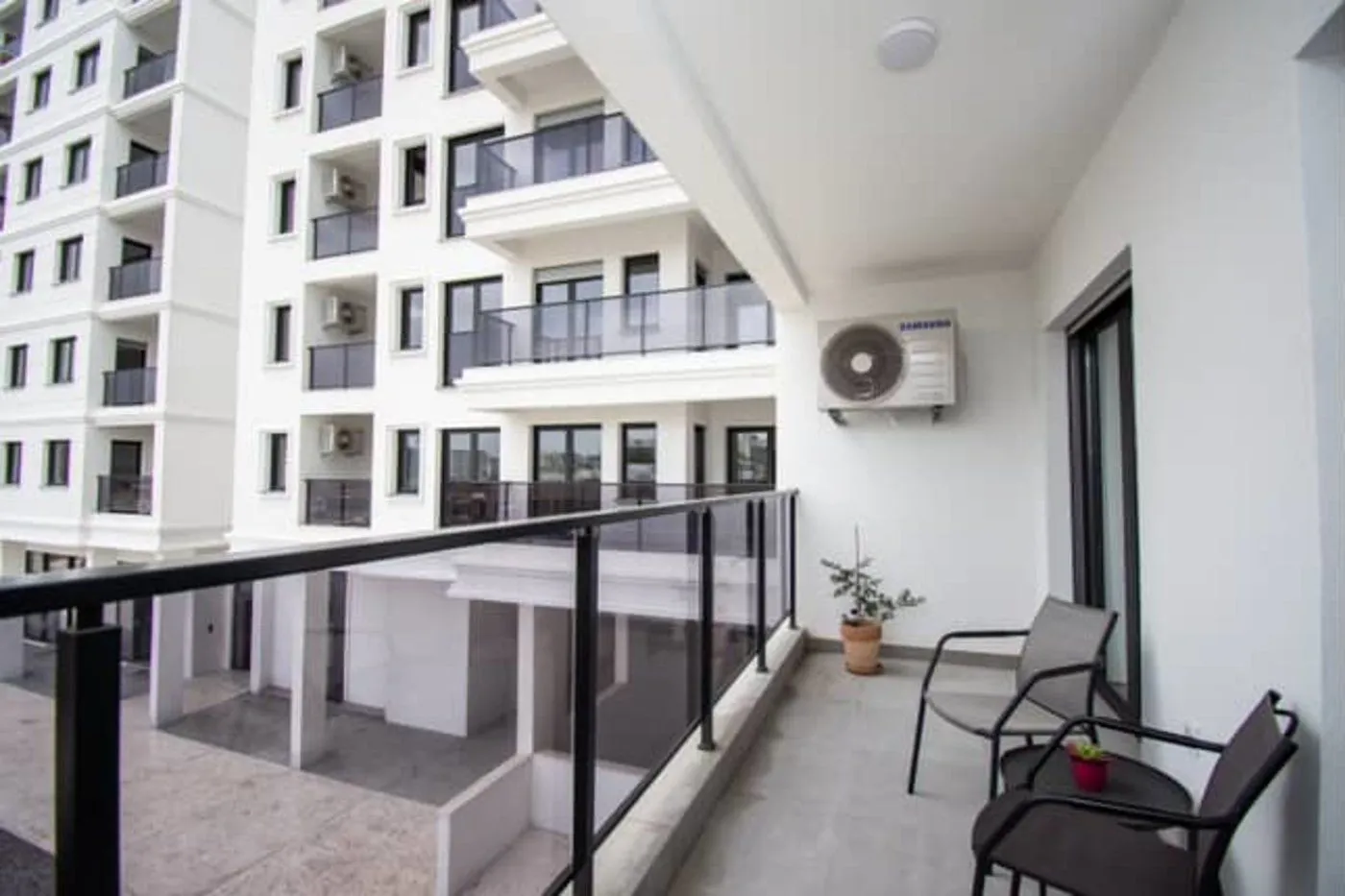 Furnished balcony with seating set and a view of the building.