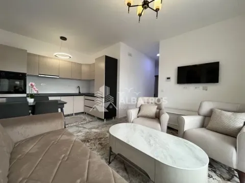 Living room with a sofa, coffee table and television, connected to the kitchen. - image 2
