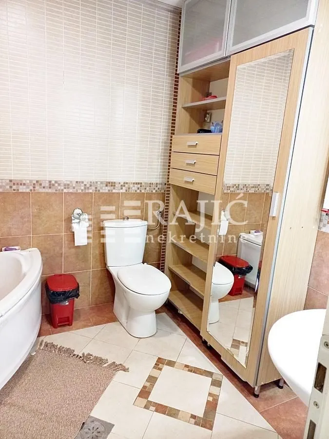 Bathroom equipped with sanitary ware, a bathtub, and a wooden cabinet.