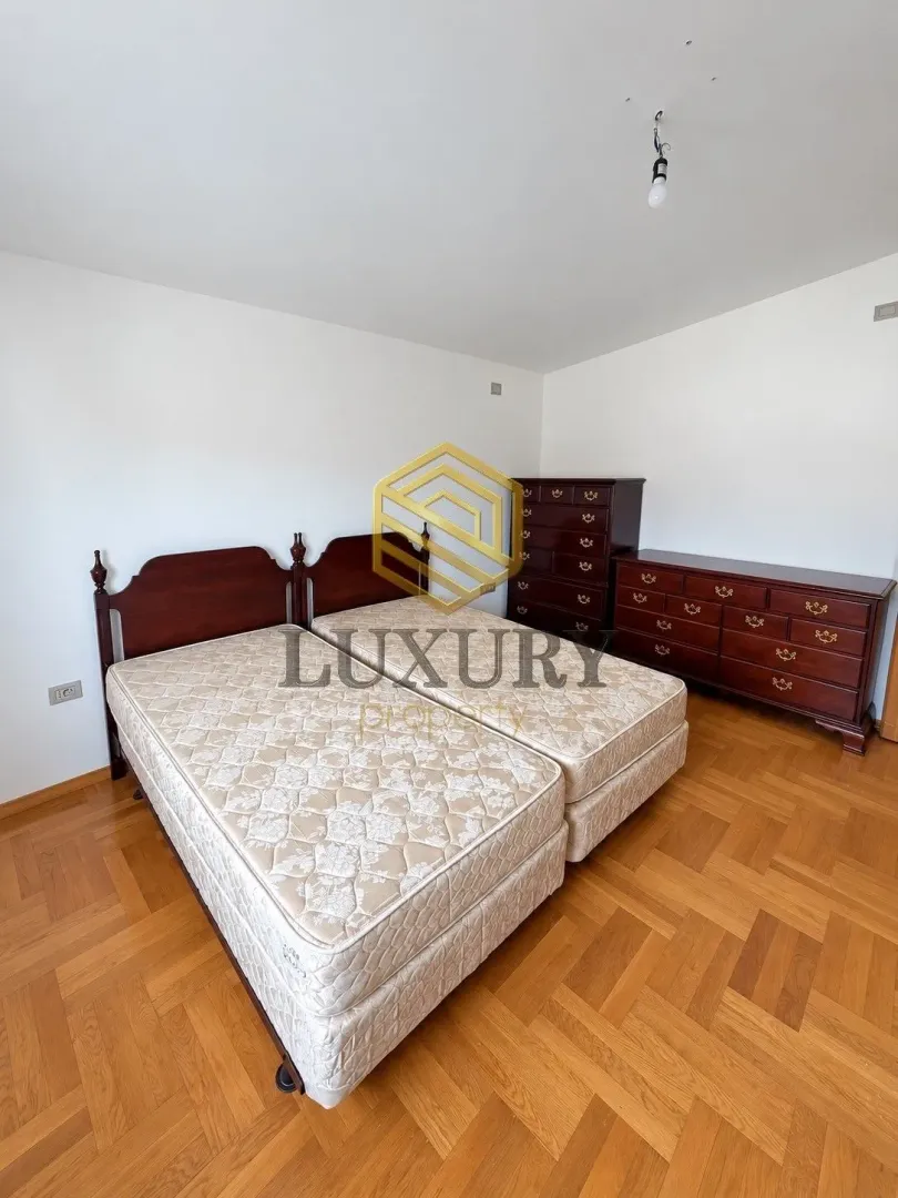 Bedroom with a double bed and wooden dresser.