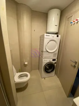 Bathroom equipped with a toilet, washing machine, dryer, and water heater. - image 5