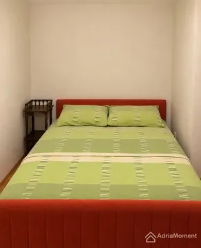Spavaća soba sa krevetom i noćnim stočićem između zidova. - image 7