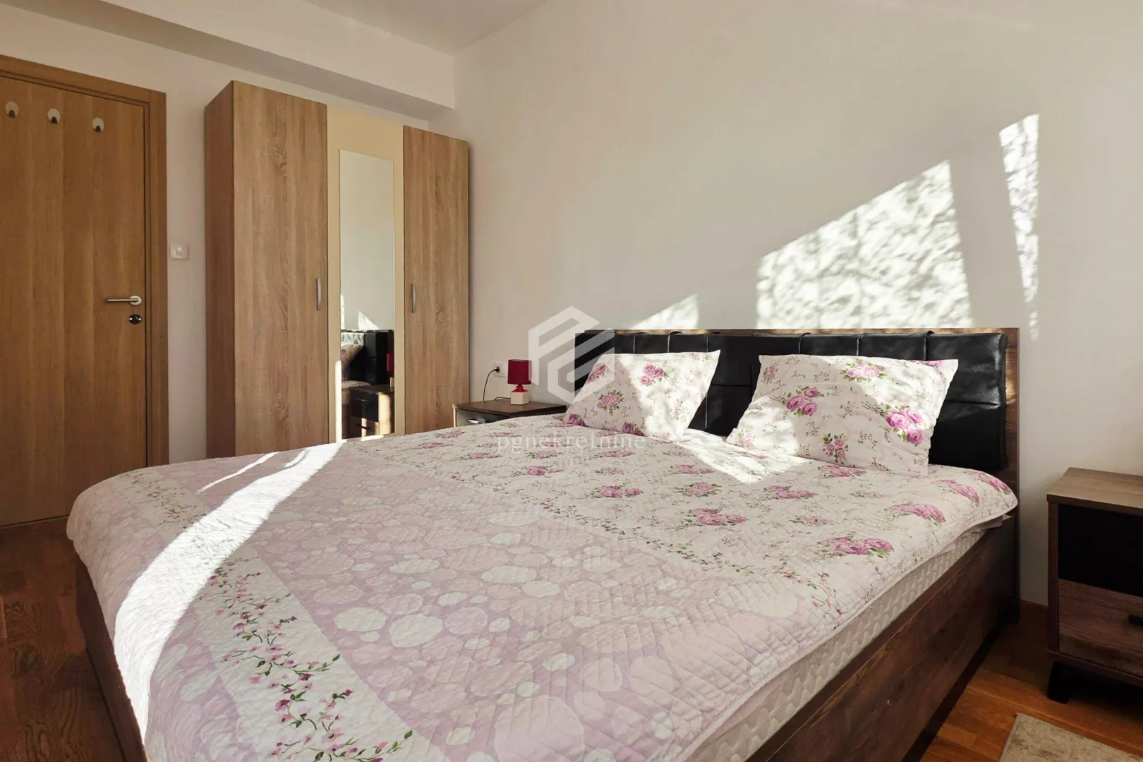 Furnished bedroom with a double bed, wardrobe, and nightstands.