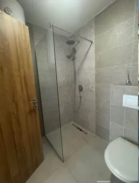 Modern bathroom with a walk-in shower and grey ceramic tiles. - image 5