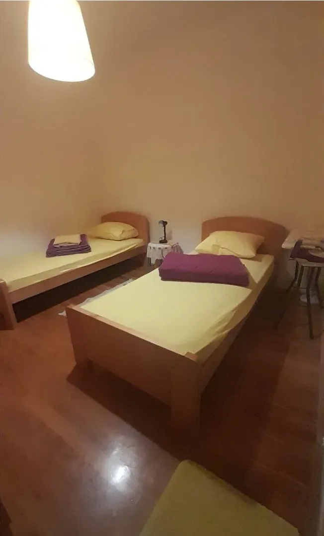 Jednostavno namještena spavaća soba sa dva singl kreveta.